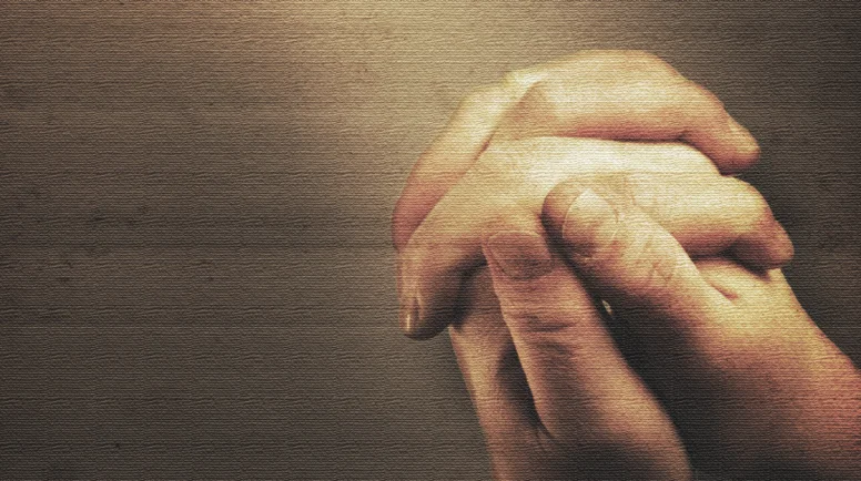 Prayers hands and sunbeam on old nostalgic background