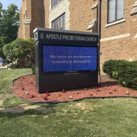 Outside of Apostle Presbyterian Church with a sign welcoming GA attendees.