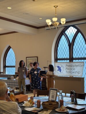 Drew Hill and Lucy Youngblood standing and smiling to accept the 2025 Peaceseeker Award.