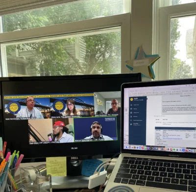Two screens in front of a window showing Gender and Sexuality Justice Committee's meeting for GA227