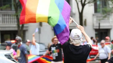 A woman waves a pride flag.