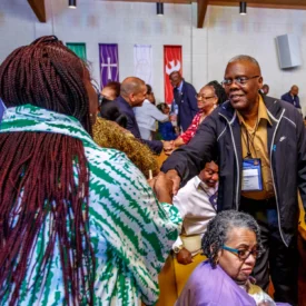Congregants shaking hands and passing the peace to one another.