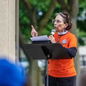 Margery Rossi, coordinator of gun violence prevention with the Presbyterian Peace Fellowship with the Presbyterian Peace Fellowship and pastor at South Presbyterian Church in Dobbs Ferry, NY, speaks into a microphone.