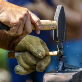 Blacksmith Jeff Wild hammers a former pistol barrel into a cross.