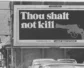 A billboard that reads: "Thou shalt not kill" with a picture of a gun