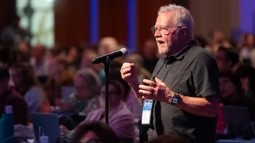 A man speaks behind a microphone