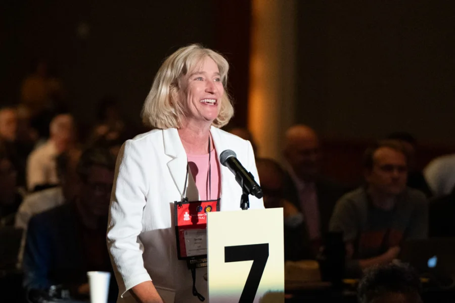 A woman stands behind a microphone