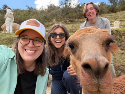 A selfie with an adult, two teens and an alpaca.