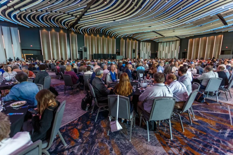 A room full of people sitting at tables and eating