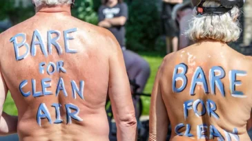Two participating of the Naked Bike Ride with painted backs stating "Bare for Clean Air"