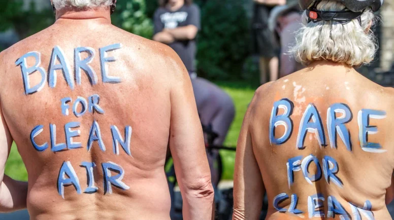 Two participating of the Naked Bike Ride with painted backs stating "Bare for Clean Air"