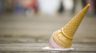 An ice cream cone that's fallen on the ground.