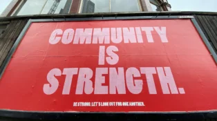 Outdoor sign that reads "community is strength"
