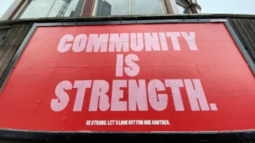 Outdoor sign that reads "community is strength"