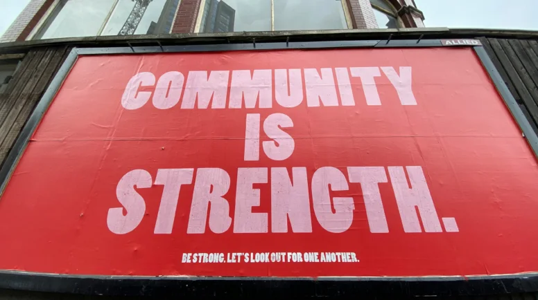 Outdoor sign that reads "community is strength"