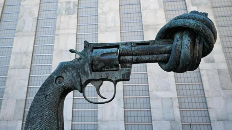 A statue of a gun with a knot at the end of it.