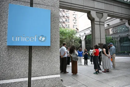 A group of Presbyterian young adults pray in the background. A sign for UNICEF in the foreground.