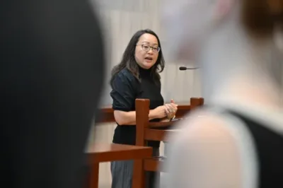 The Rev. Jihyun Oh, Stated Clerk of the General Assembly and Executive Director of Presbyterian Life & Witness, stands at a podium. 
