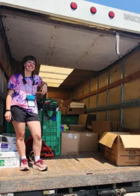 Emily Hooker of Ferncliff Camp and Conference Center stands inside a box truck.