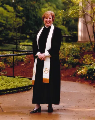 Joanna Adams poses for a professional photo, wearing her preaching robs and a white stole.