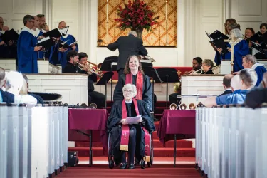 Joanna Adams, sitting in a wheel chair, leads a congregation in worship