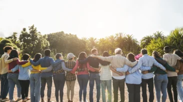 Group of multigenerational people hugging each other.