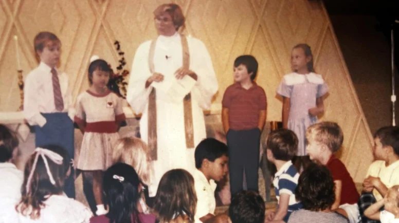 A vintage photo of Joanna Adams standing amongst children.