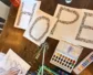 Art supplies are displayed on a table, along with four pages of paper that together say "hope."