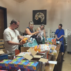 A table is covered with activities and four individuals pack bags for Borrowed Hope.
