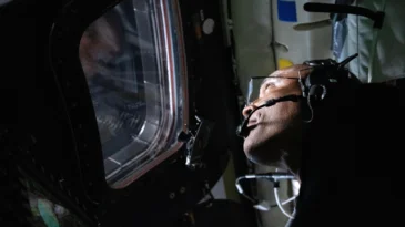 Astronaut looking out of the window on a spaceship
