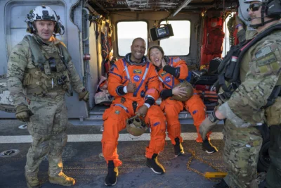Two astronauts sitting on a helicopter 