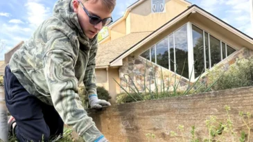 Person on the ground gardening in front of a PCUSA church