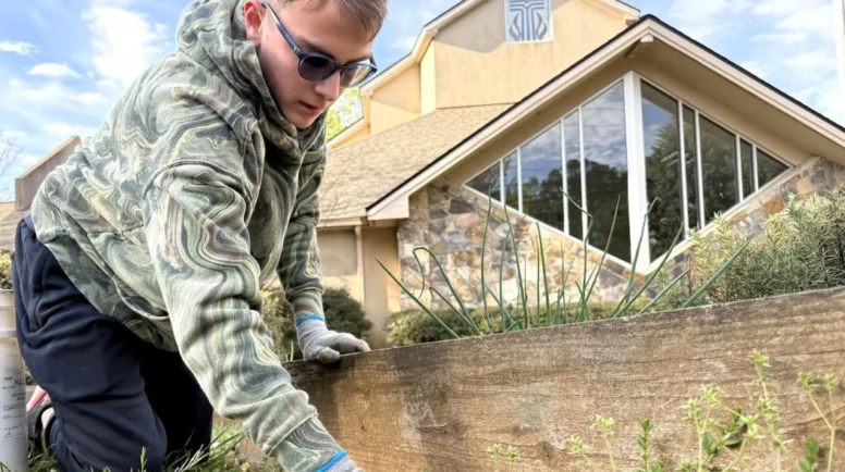 Person on the ground gardening in front of a PCUSA church