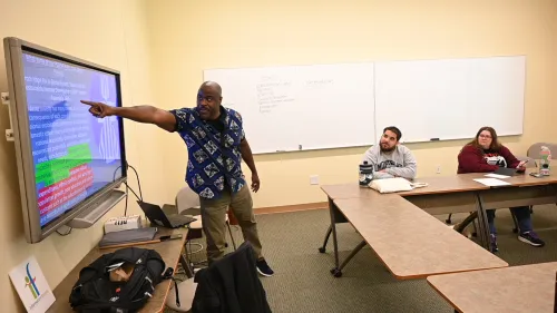The Rev. Dr. Alonzo Johnson points to a screen in a classroom with young adults.