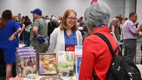 The Rev. Rebecca Barnes stands behind a table with resources