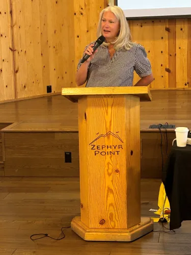A woman stands behind a podium