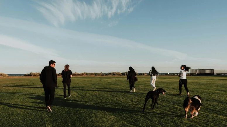 A group of young people walking across a field