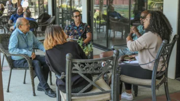 A small group of adults sits in a circle and has a conversation