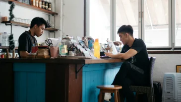 Two young men stand around at a local coffee shop
