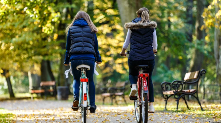 Healthy lifestyle - people riding bicycles in city park
